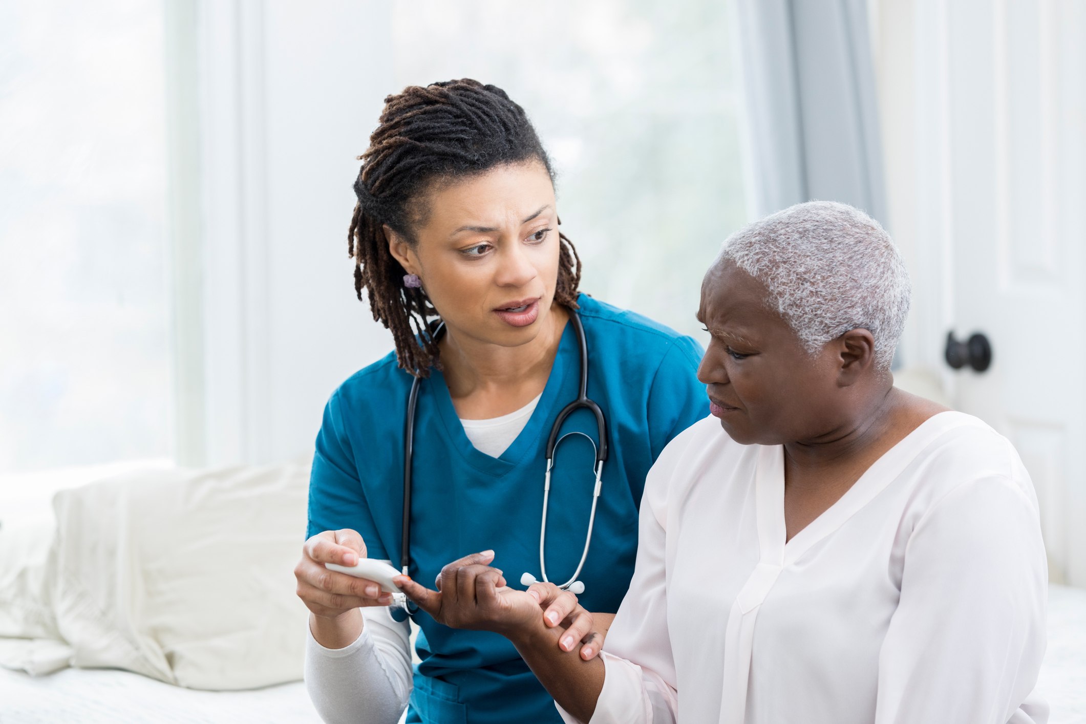 Concerned nurse checks patient's blood sugar